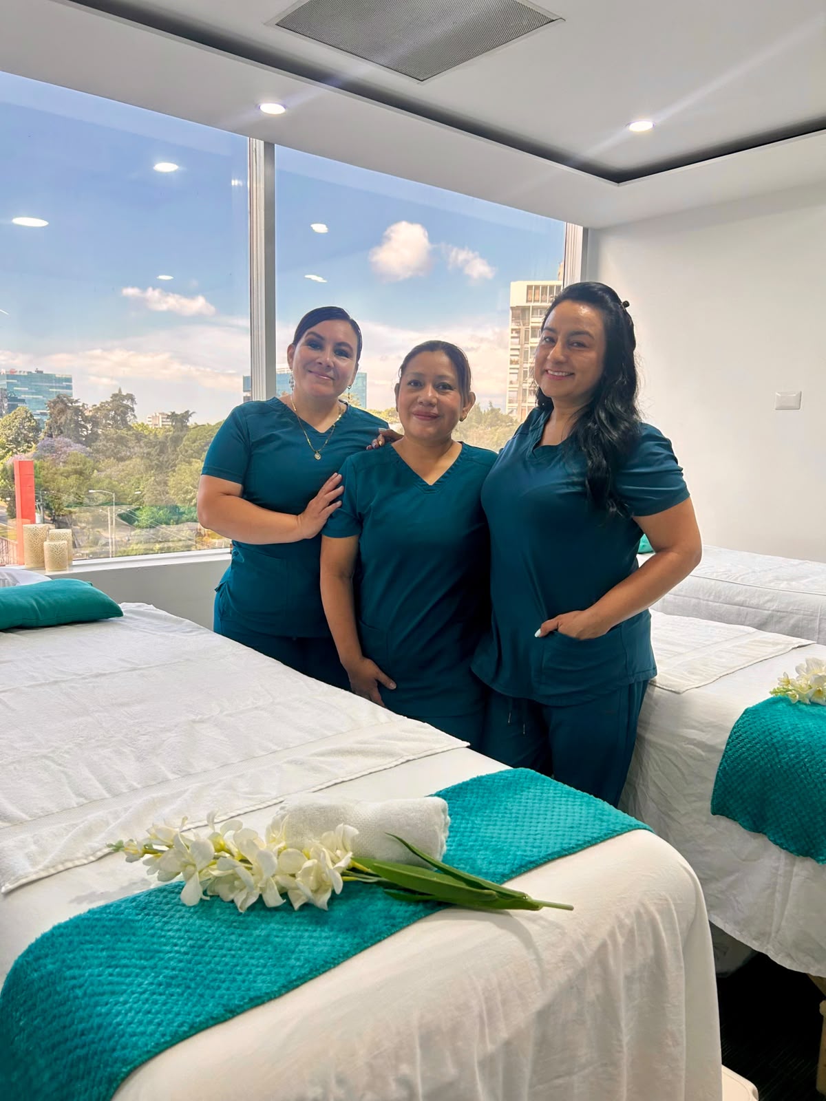 Equipo de terapeutas certificadas de Lirios Spa junto a camilla de masaje