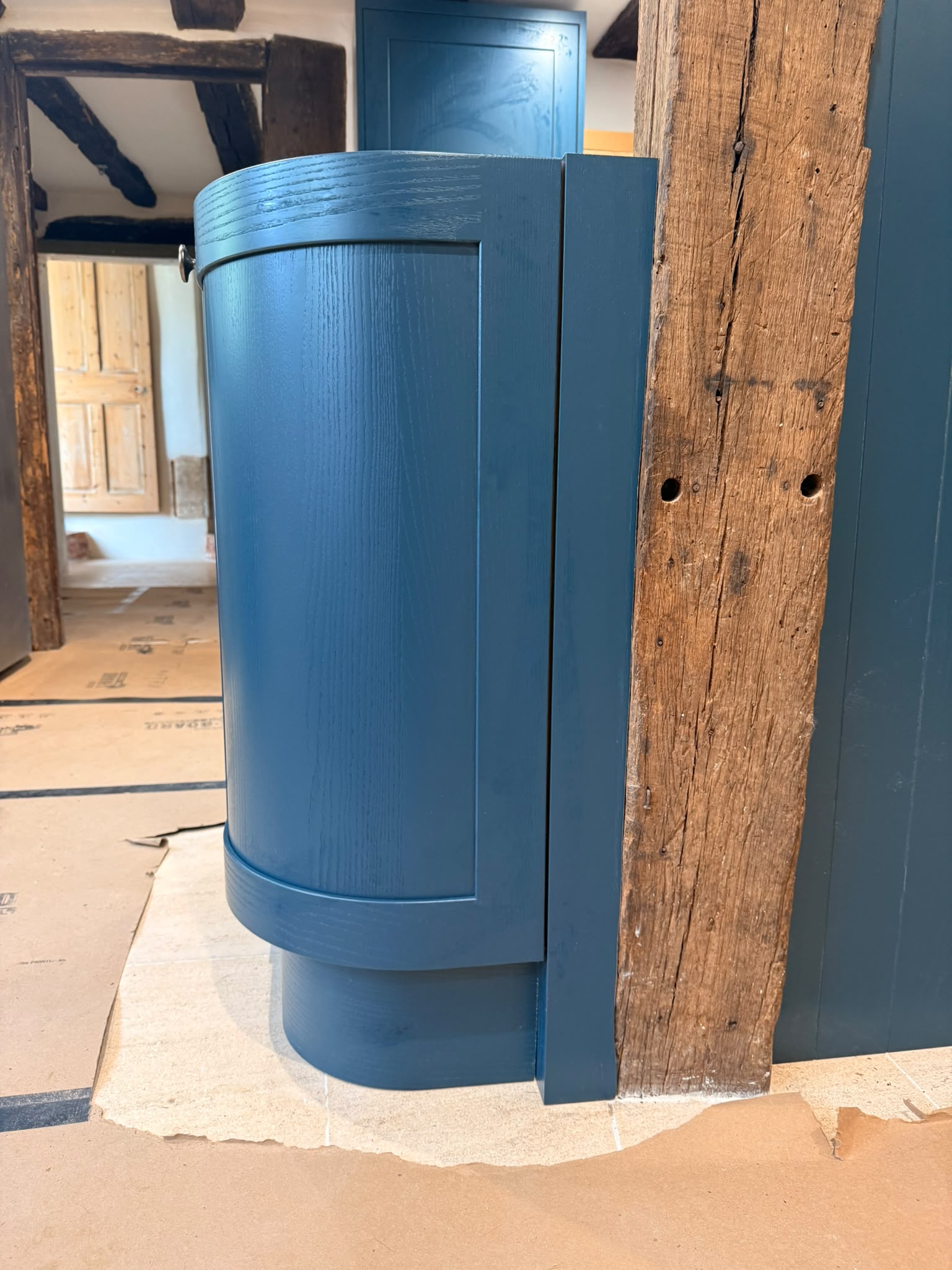 Curved painted shaker cabinet scribed to heritage beam — Amesbury