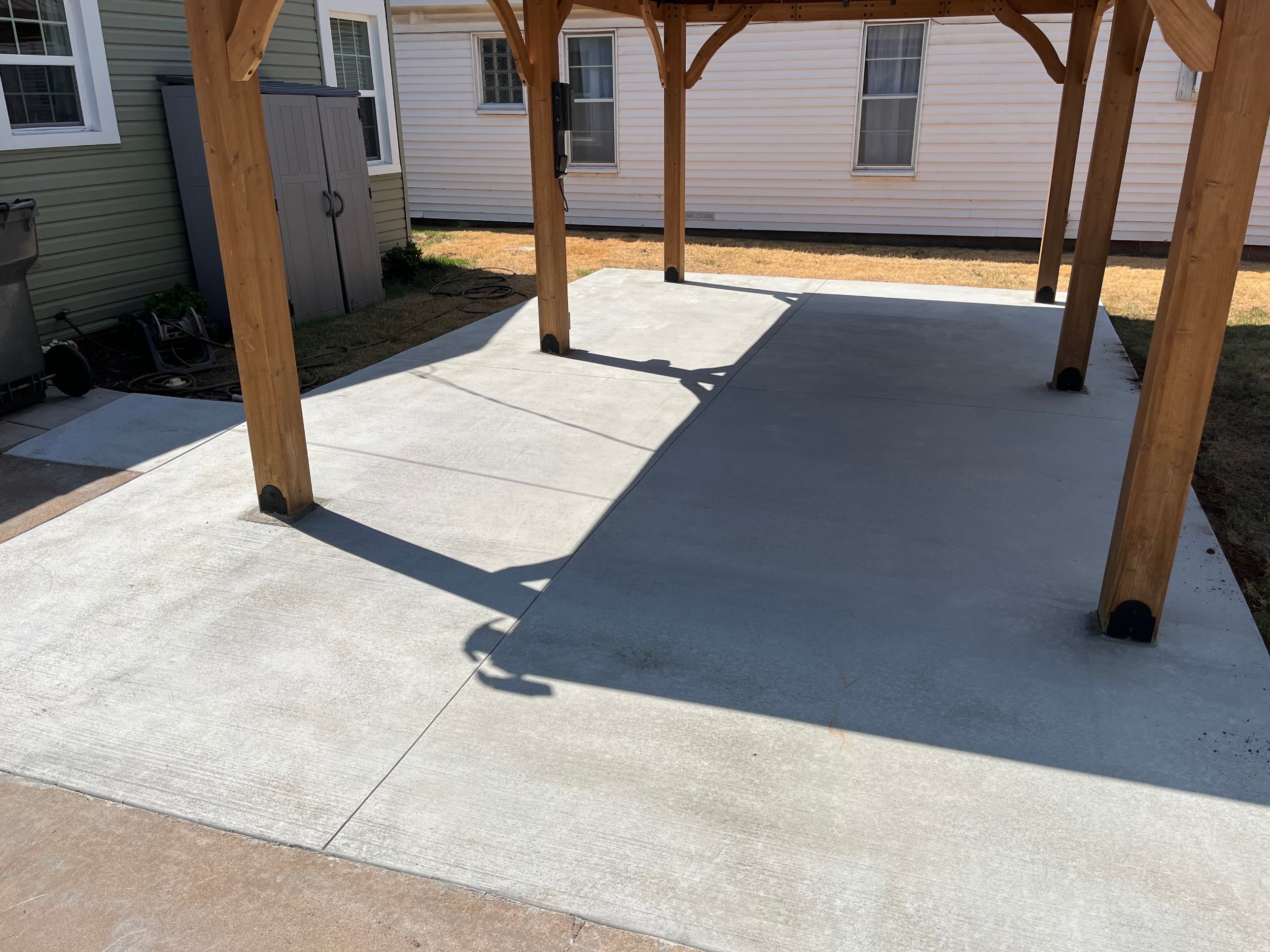 New concrete patio slab under a wooden pergola in Wichita Falls, TX