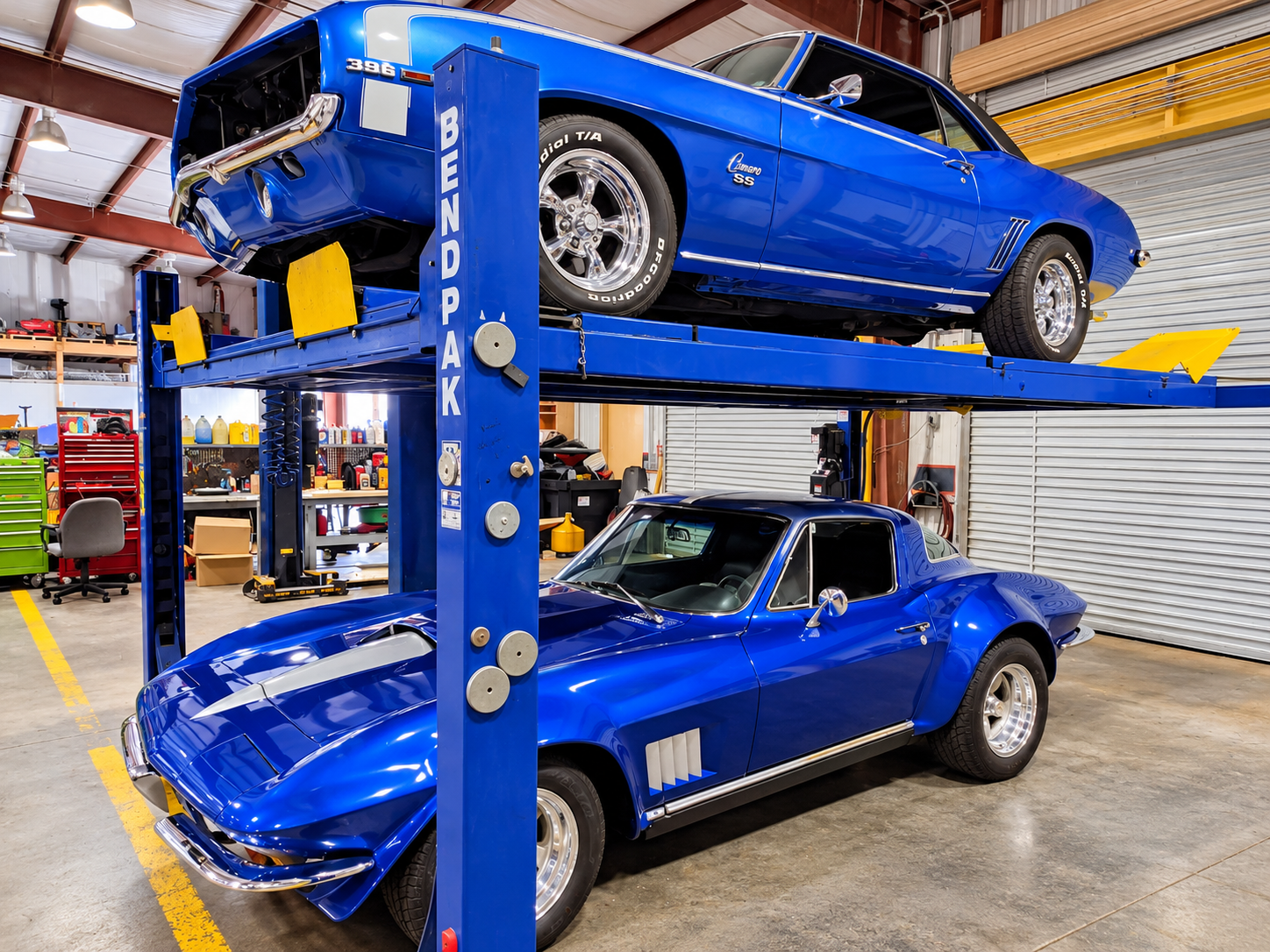 Classic Chevrolet Corvette and Camaro SS on automotive lift inside Larry's Auto Service shop bay