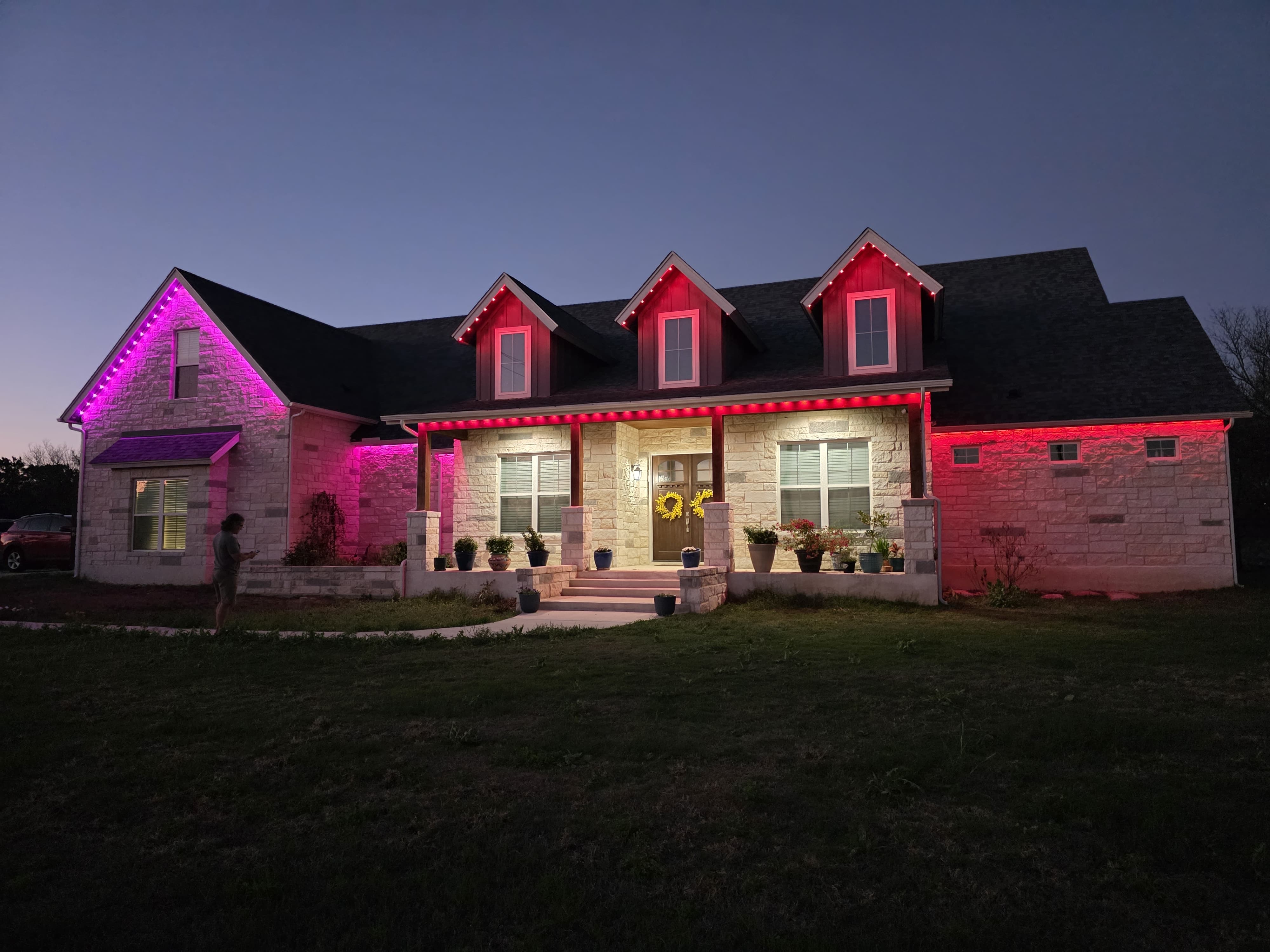 Single-story home illuminated with custom color scenes controlled via smartphone app