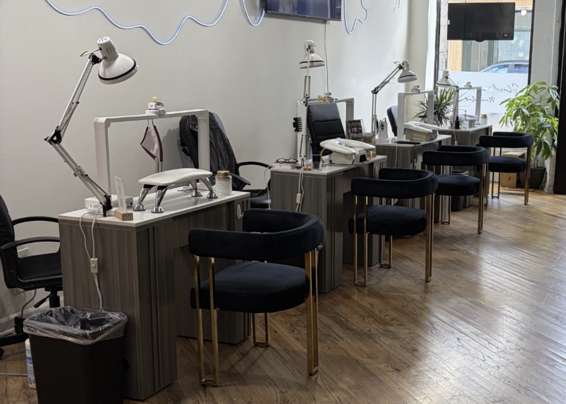 Estaciones de manicura profesionales en Alura Beauté con sillas elegantes, lámparas de trabajo y mesas equipadas