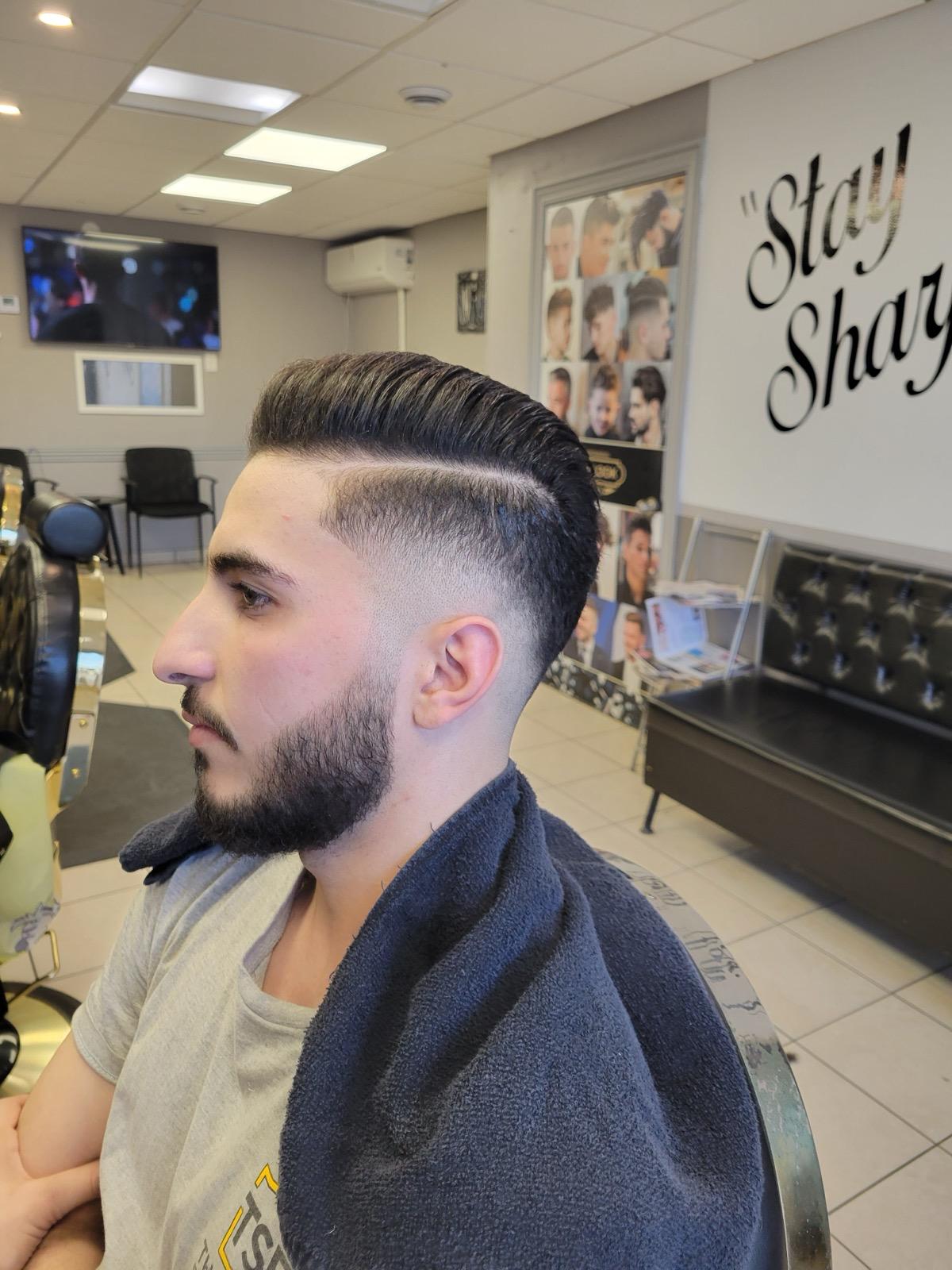 Classic pompadour side part and low skin fade with beard shaping