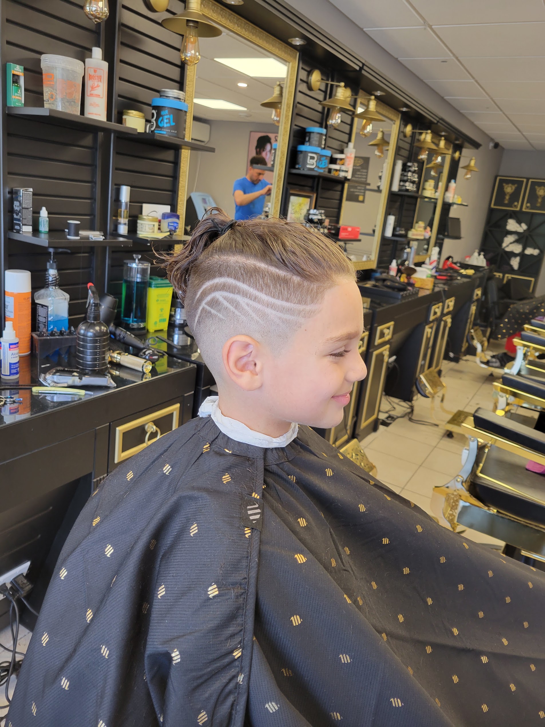 Custom artistic shaved hair design and top knot for kids