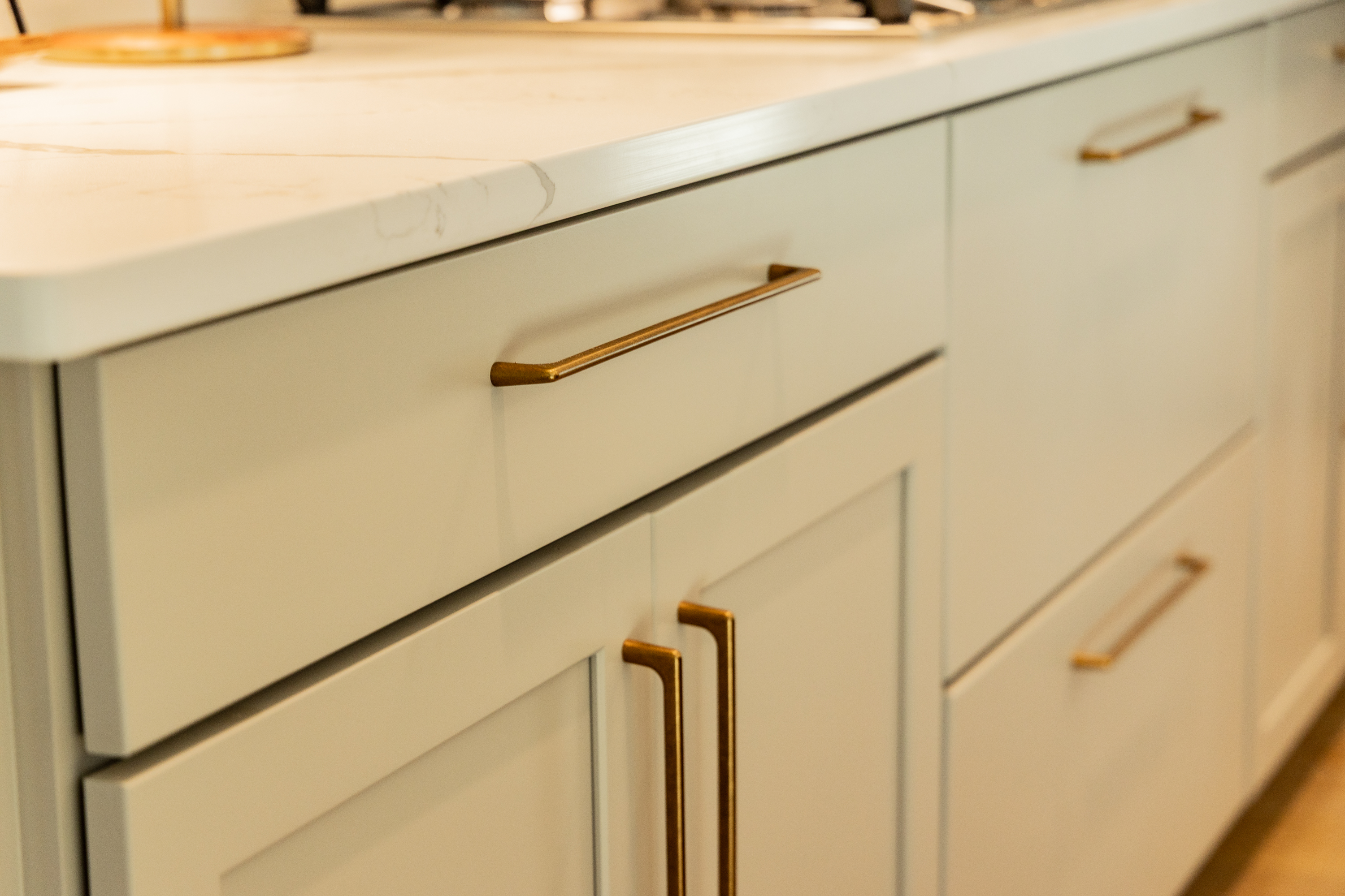 Close-up of unlacquered antique brass cabinet hardware pulls and artisan craftsmanship in Everstead kitchen remodel