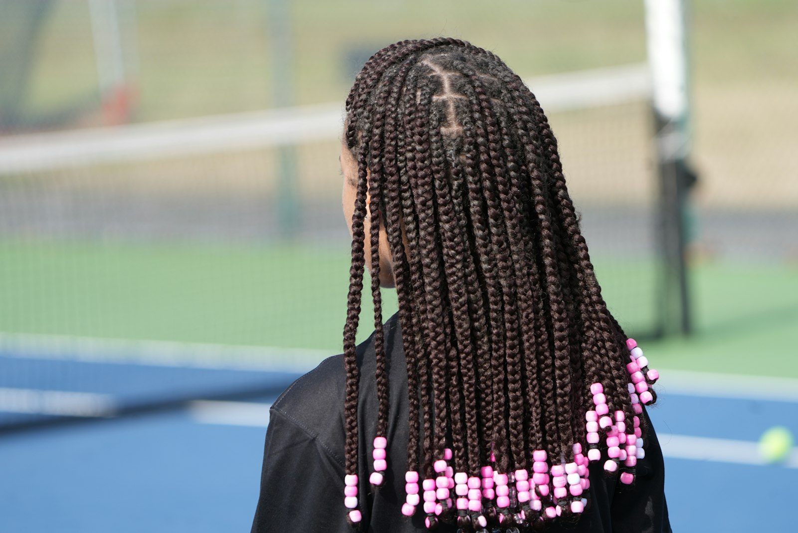 A woman with long, neatly parted box braids, a protective braided style crafted at La Salon in Pickering