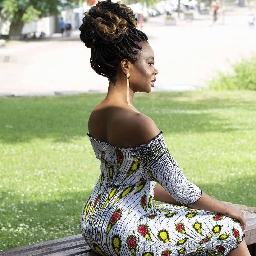 Elegant profile view of sculpted loc bun styling and warm outdoor natural radiance