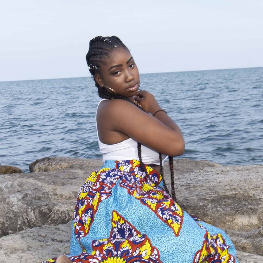 Side swept precision cornrows with dual long braided tails and silver hair rings in Pickering, Ontario