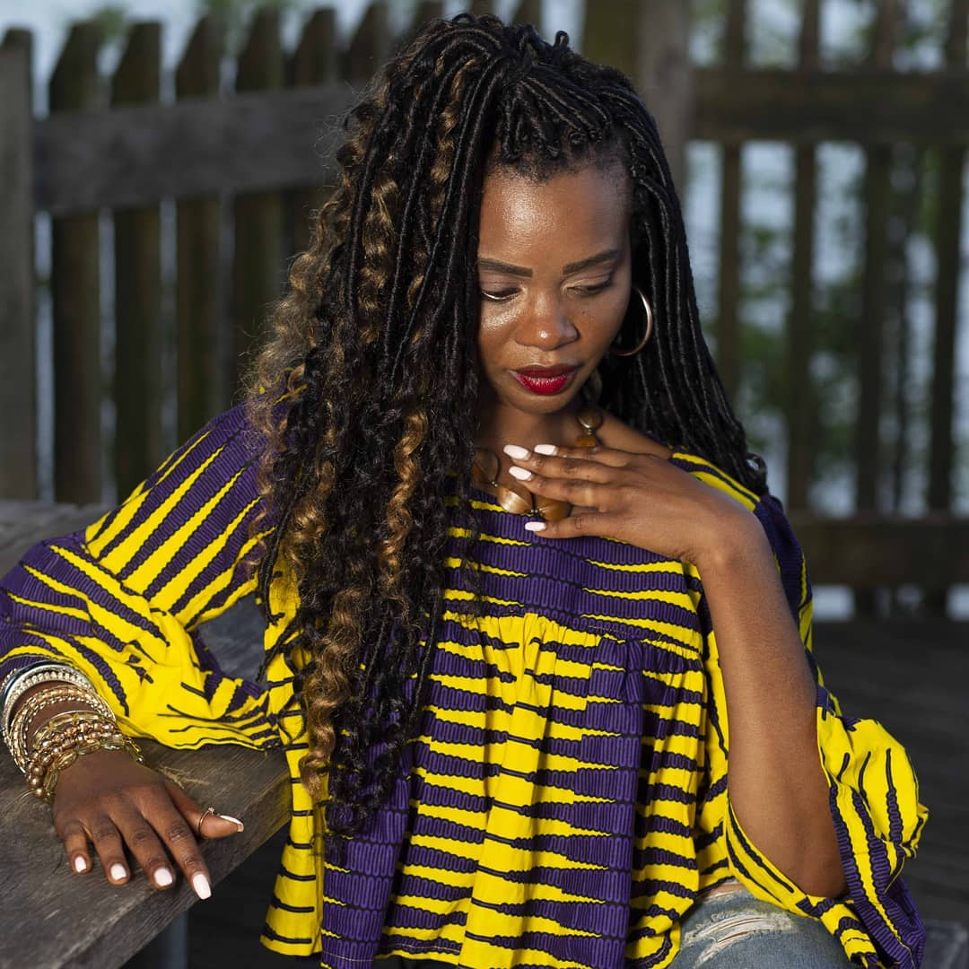 Half-up sculpted goddess locs with honey blonde spiral highlights by La Salon in Pickering, Ontario