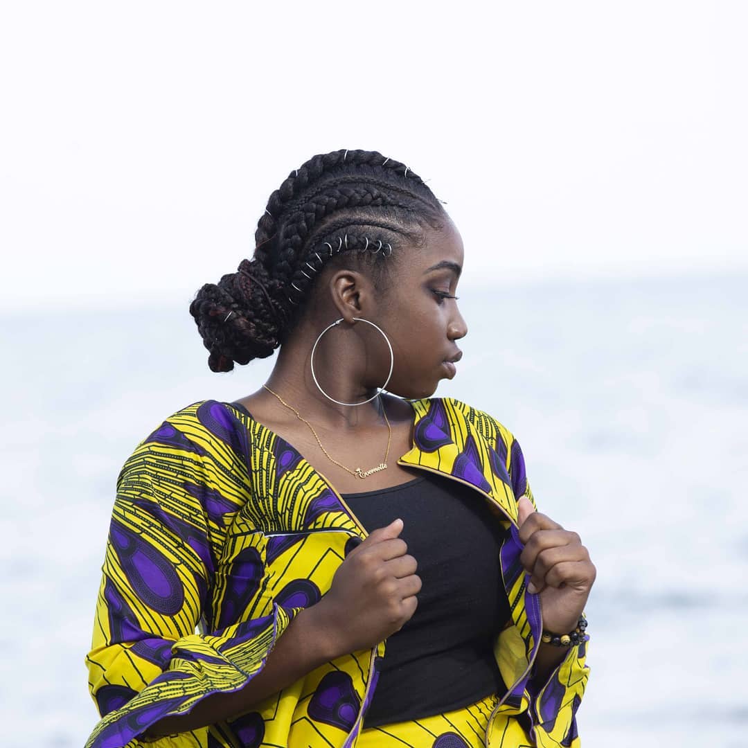 Side profile of sculpted curved feed-in cornrows and braided low bun with metallic rings in Pickering