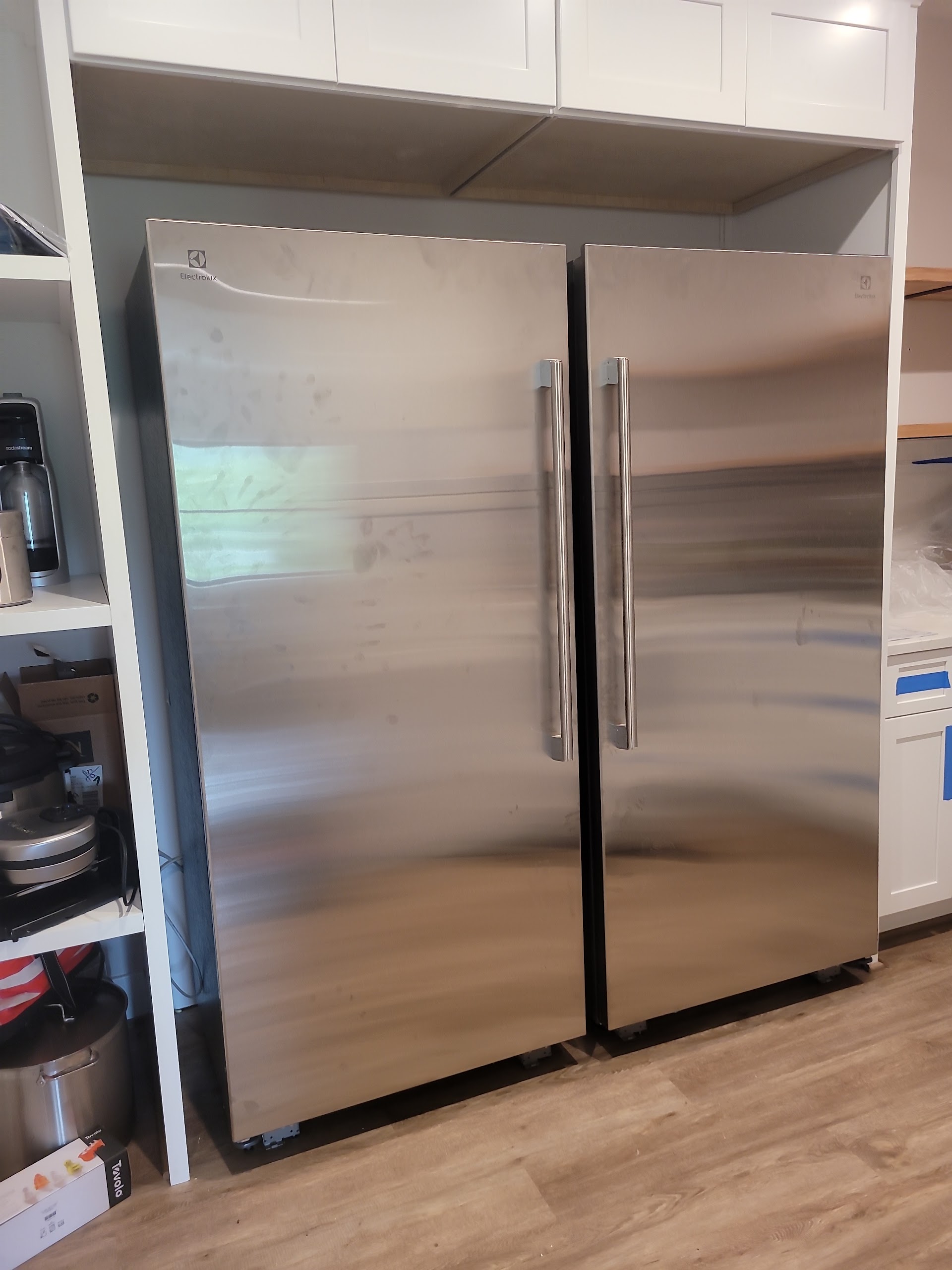 Electrolux stainless steel twin column refrigerator & all-freezer set integrated into custom white cabinetry