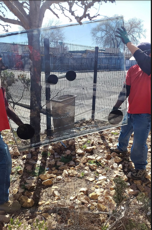 Glass on Wheels technicians handling an upright clear glass panel during on-site installation