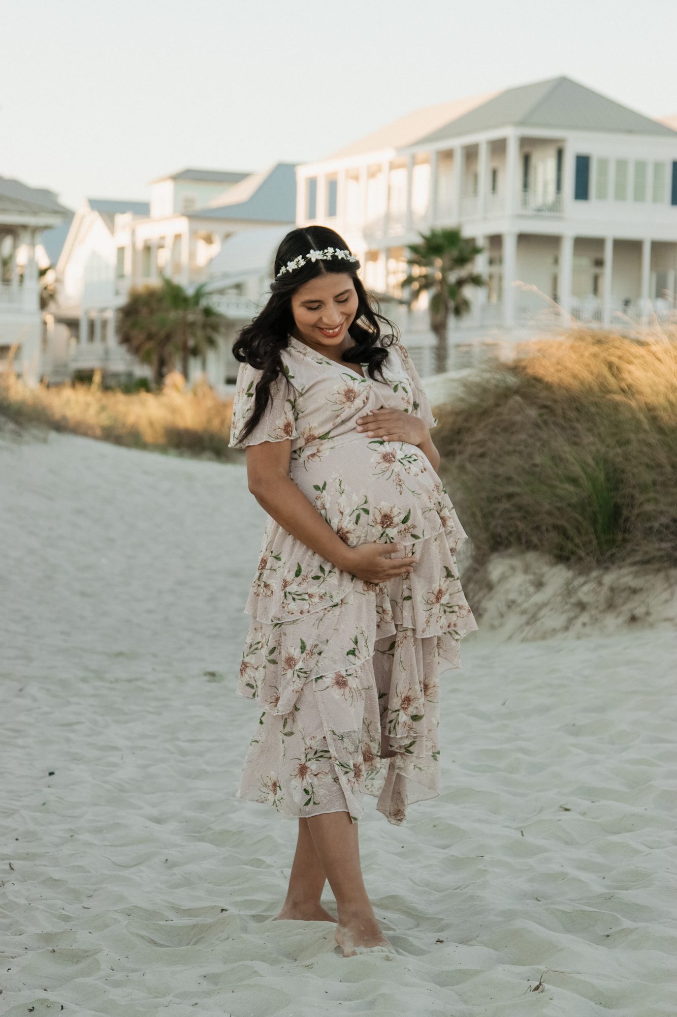 Expecting mom standing barefoot on a Galveston beach at golden hour