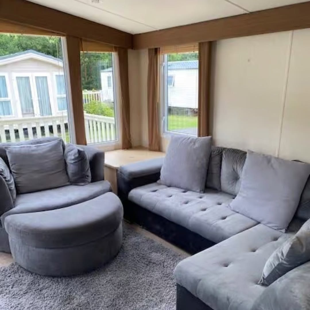 Cosy lounge with corner sofa, swivel armchair and scenic countryside views