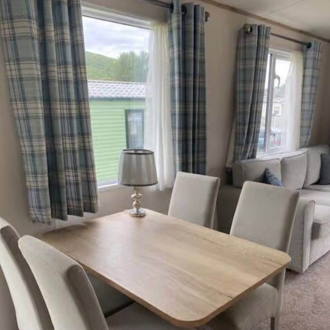 Bright dining area with tartan curtains and countryside view