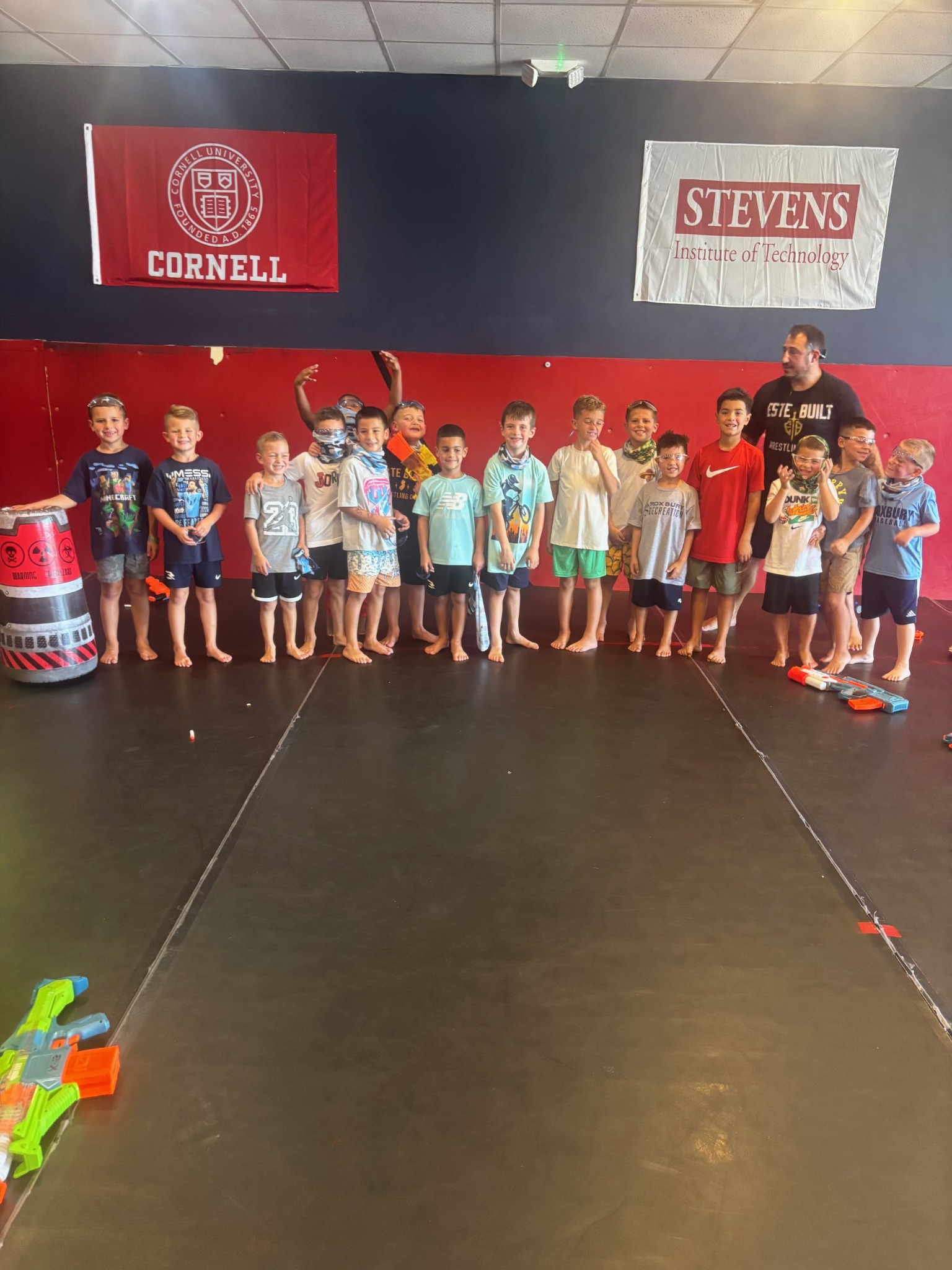 Children with a coach and Nerf blasters ready for party games at Este Built Wrestling Club