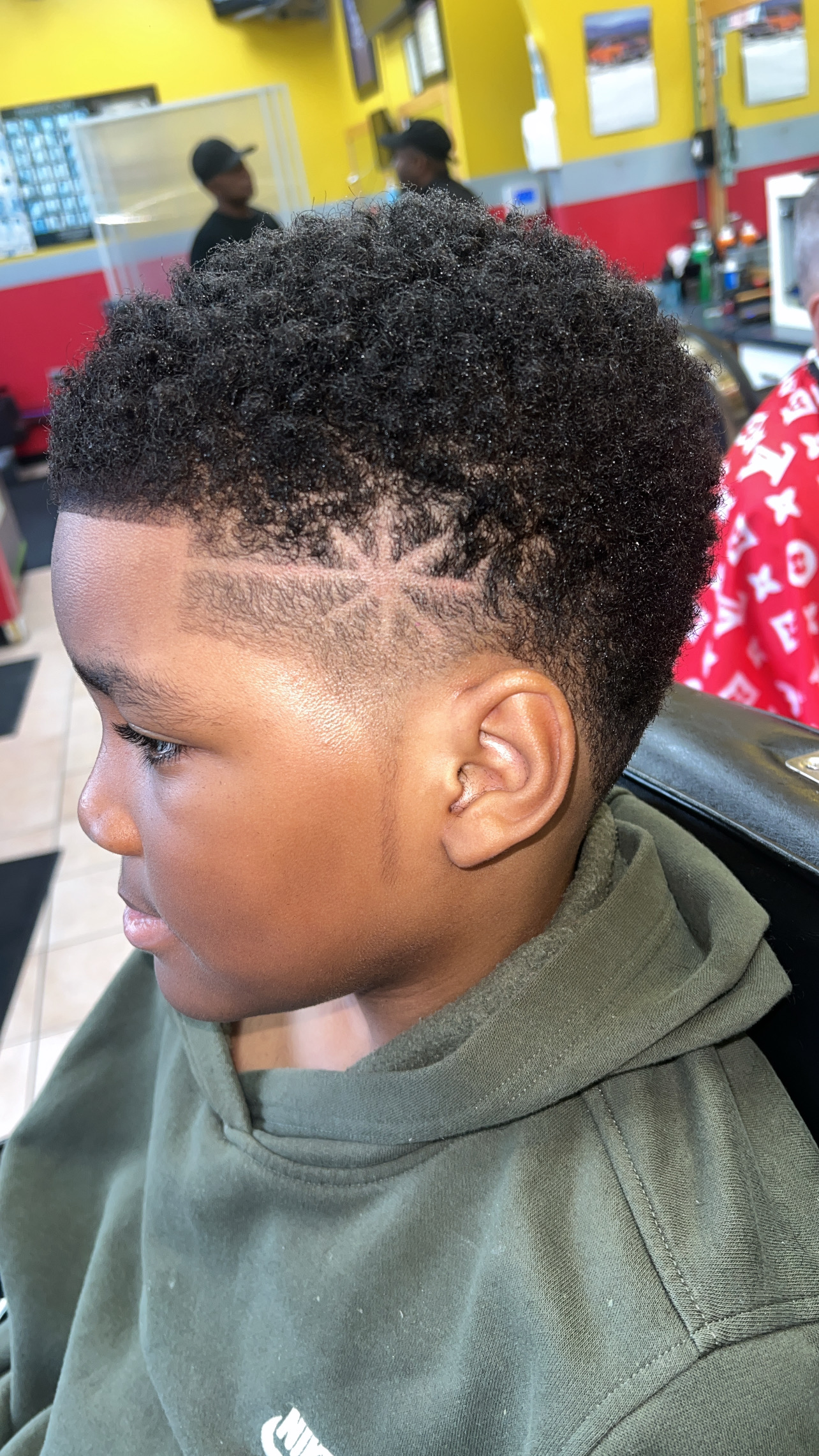 Youth burst taper fade with precision razor starburst design and natural sponge textured top