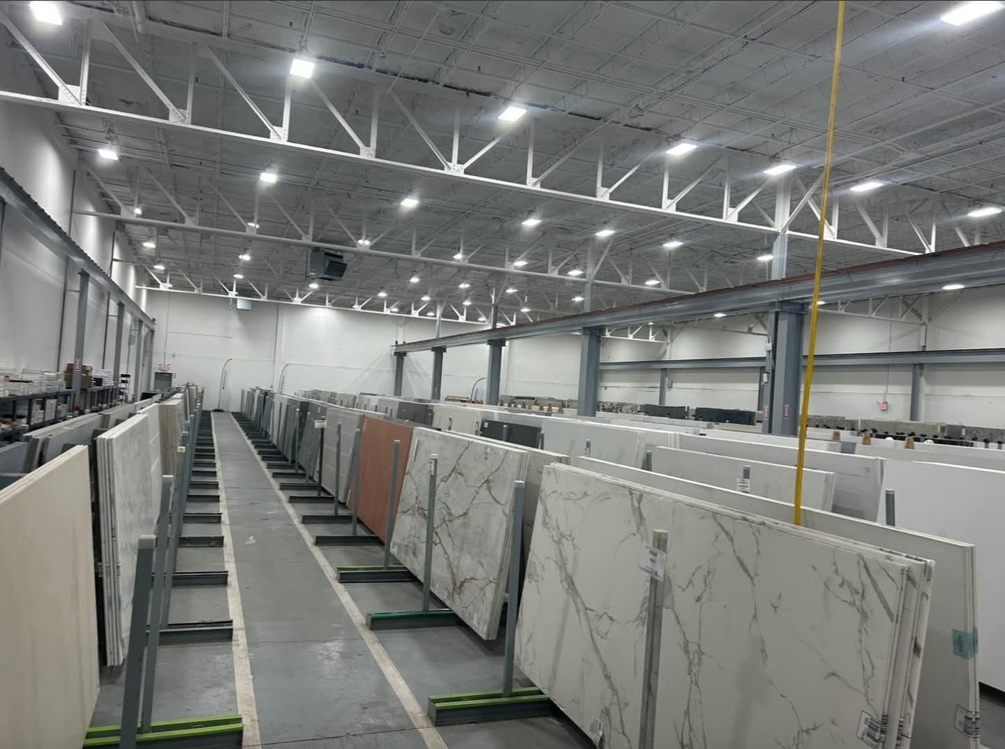 Stone and marble slab rows on A-frame racks in the Hicksville warehouse