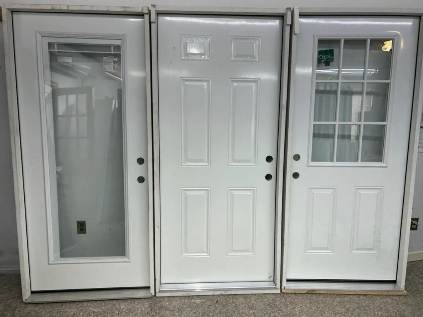 White exterior entryway doors with glass inserts and multi-panel designs