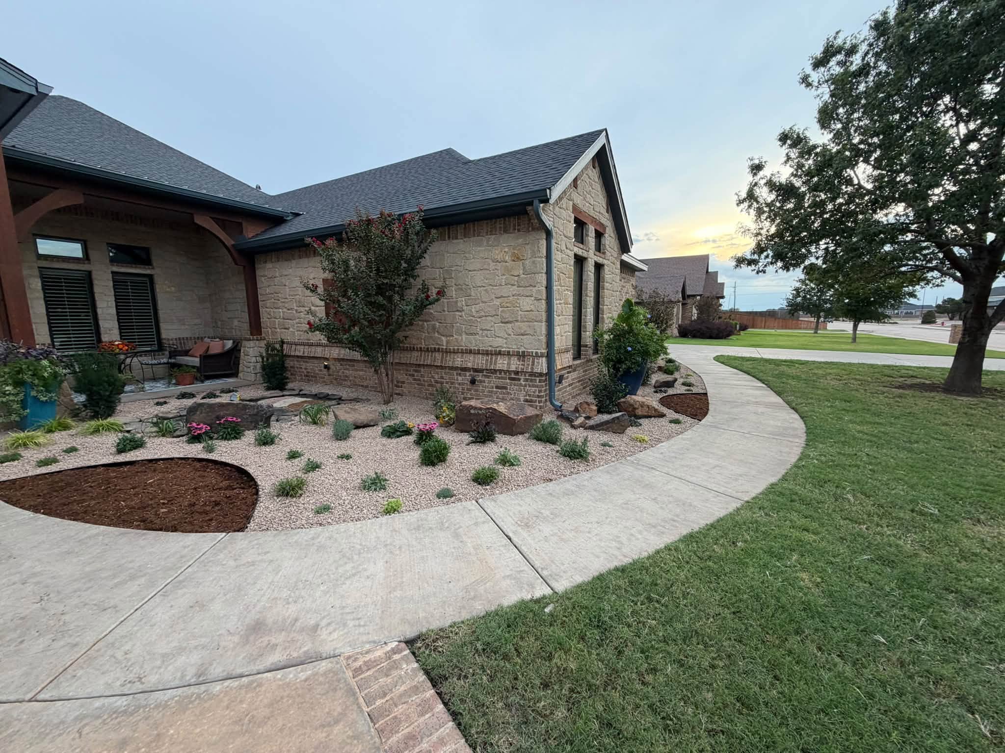 Lubbock residential · Decomposed gravel, stone boulders, blooming perennials & mulch ring