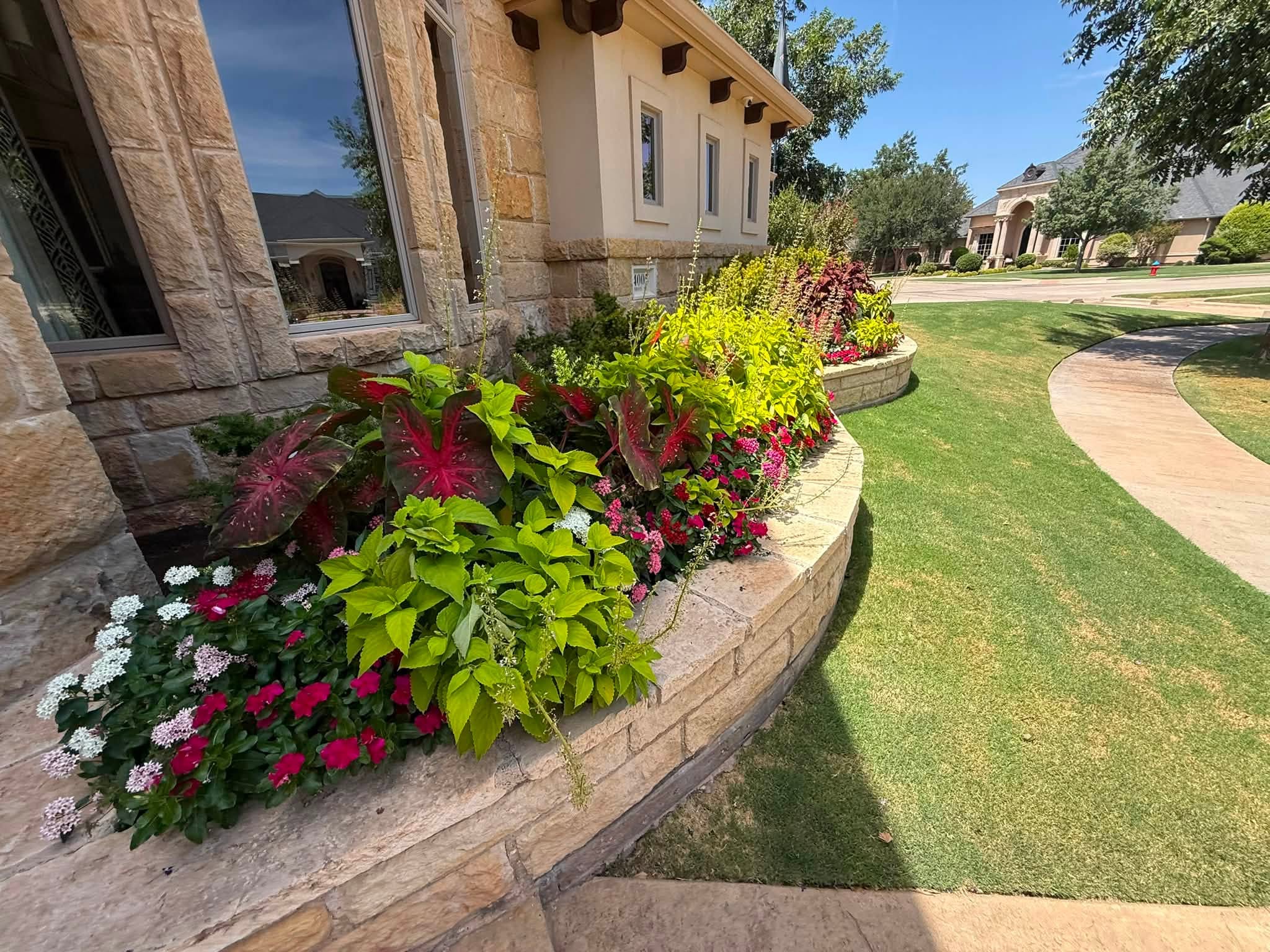 Lubbock residential · Layered stone planter with lush textured foliage & annuals