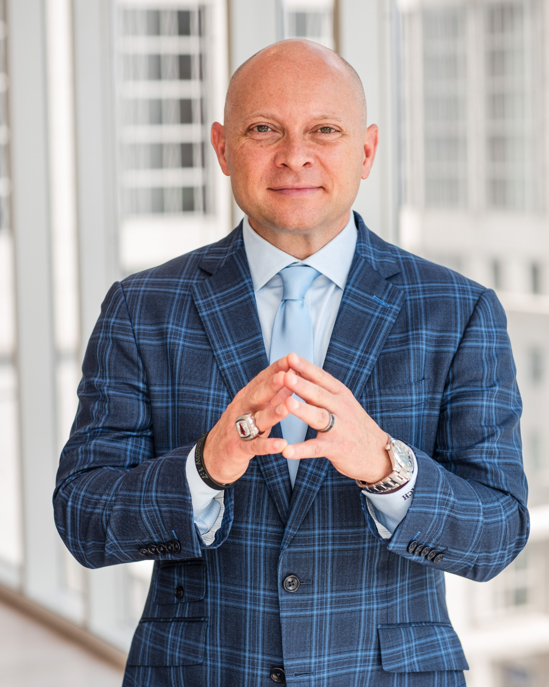 Coach Micheal Burt in navy plaid suit hosting the Special Miami Live Experience