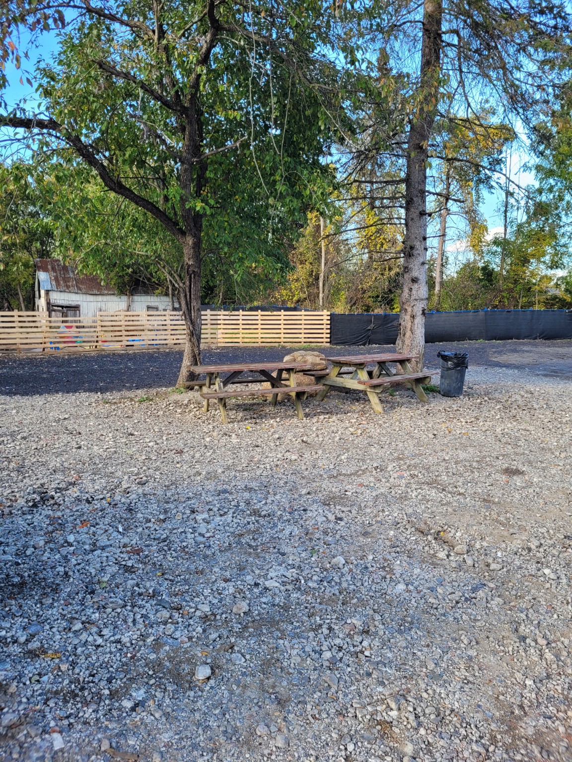 Wooded picnic tables under mature trees on the Farmstead property