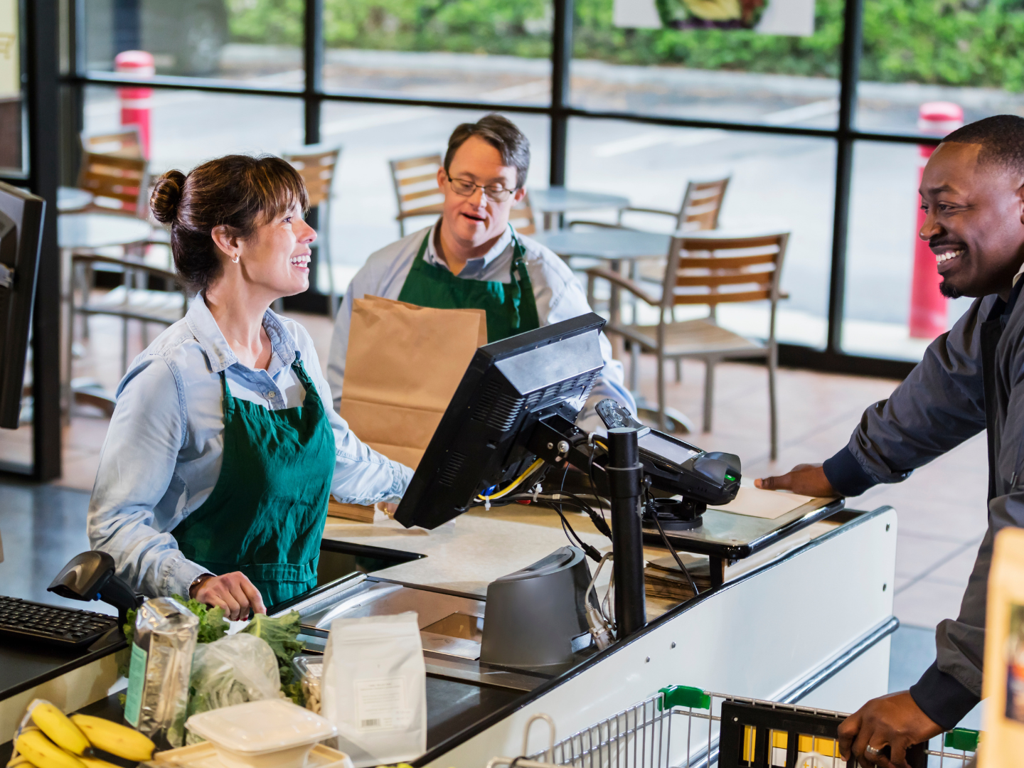 A restaurant owner at a modern cafe counter with a card reader
