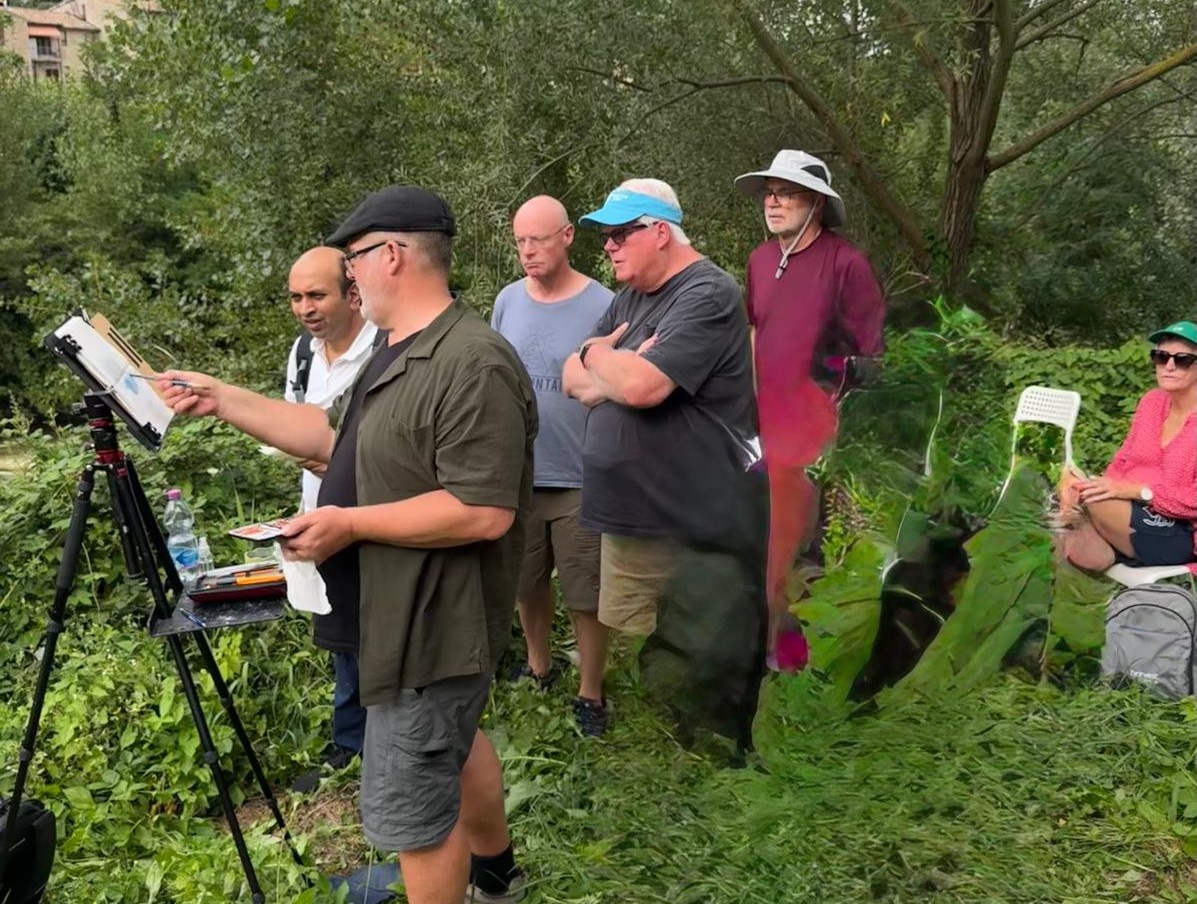 Rod Moore demonstrating painting techniques outdoors at the easel with students