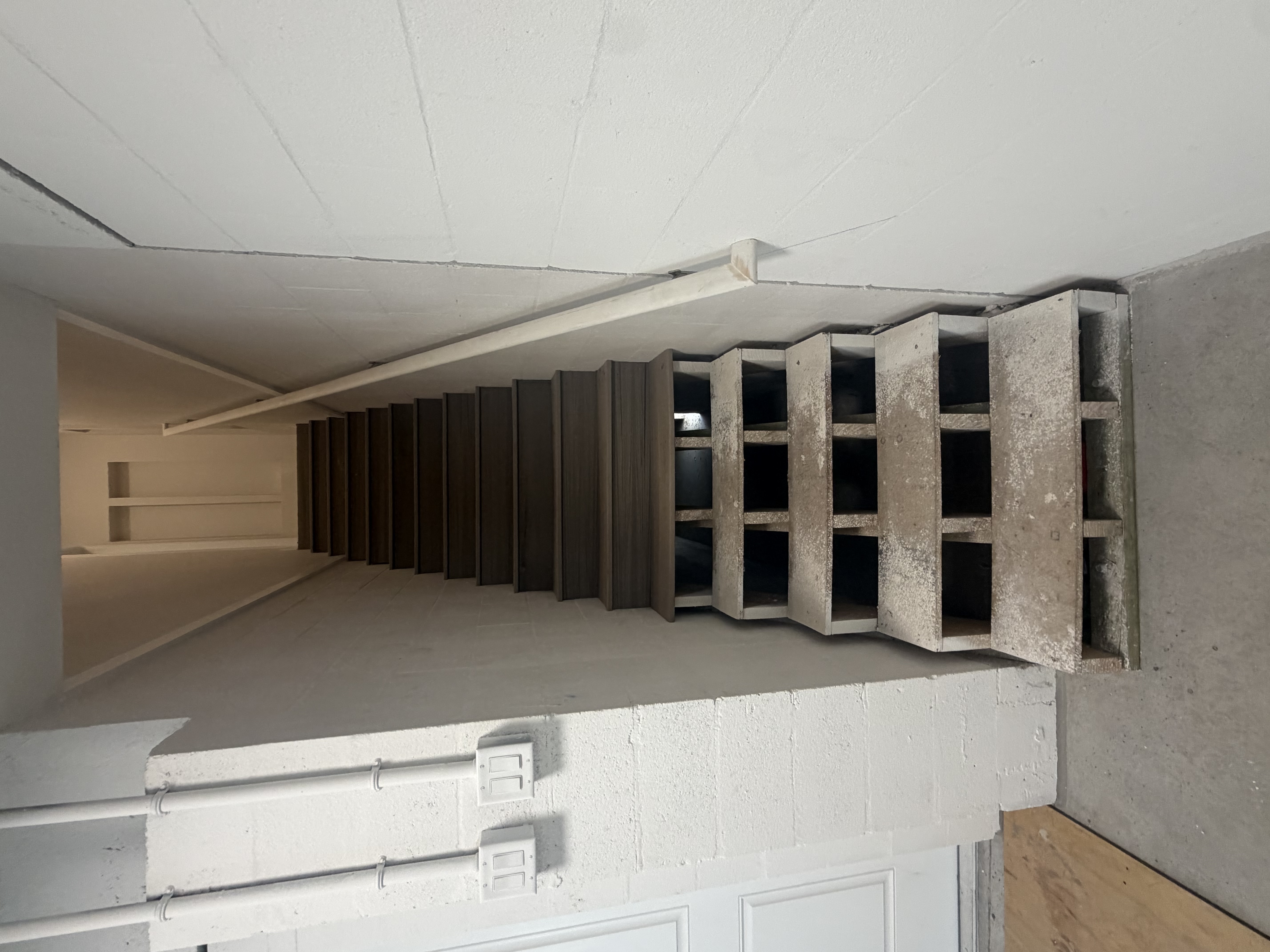 Interior stair remodel showing newly installed dark wood treads alongside the open staircase framework under construction