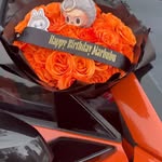 10 Rose Petals custom bright orange rose arrangement with birthday sash and playful collector charm