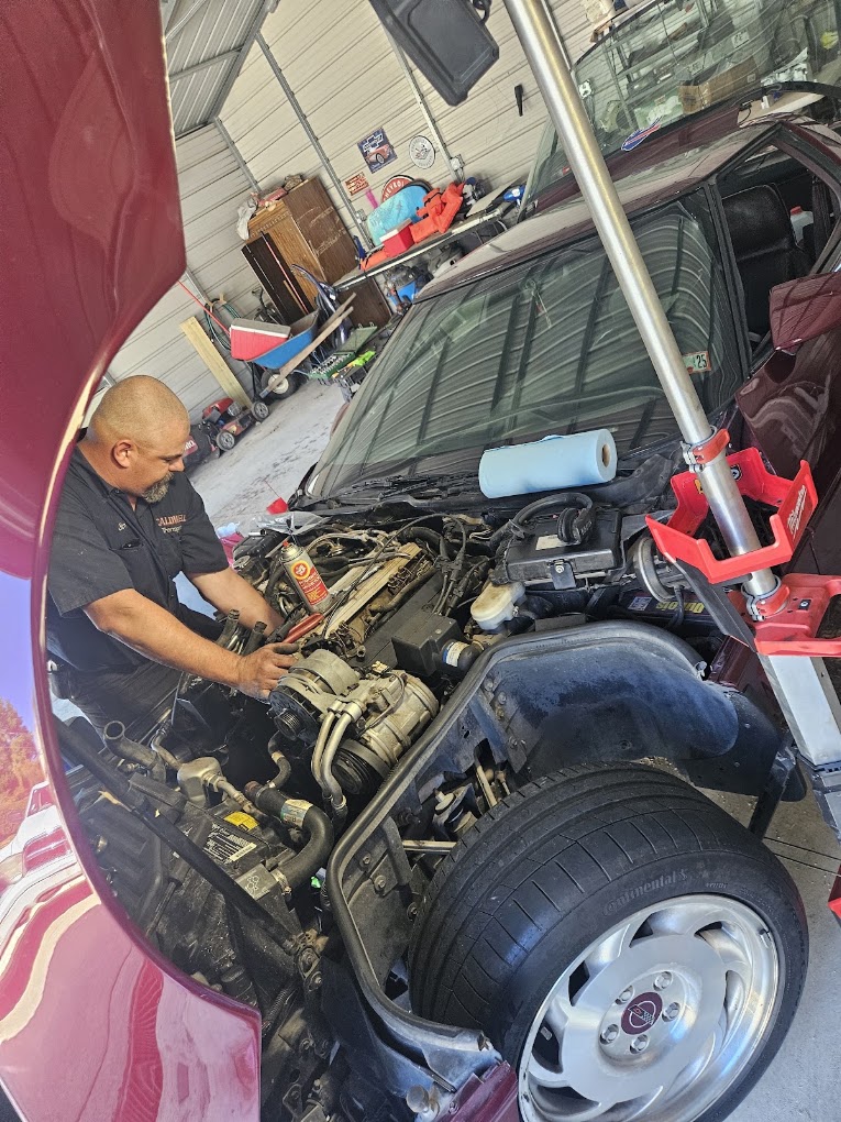 Caldwell Services mechanic working directly under the hood on an engine in New Castle PA