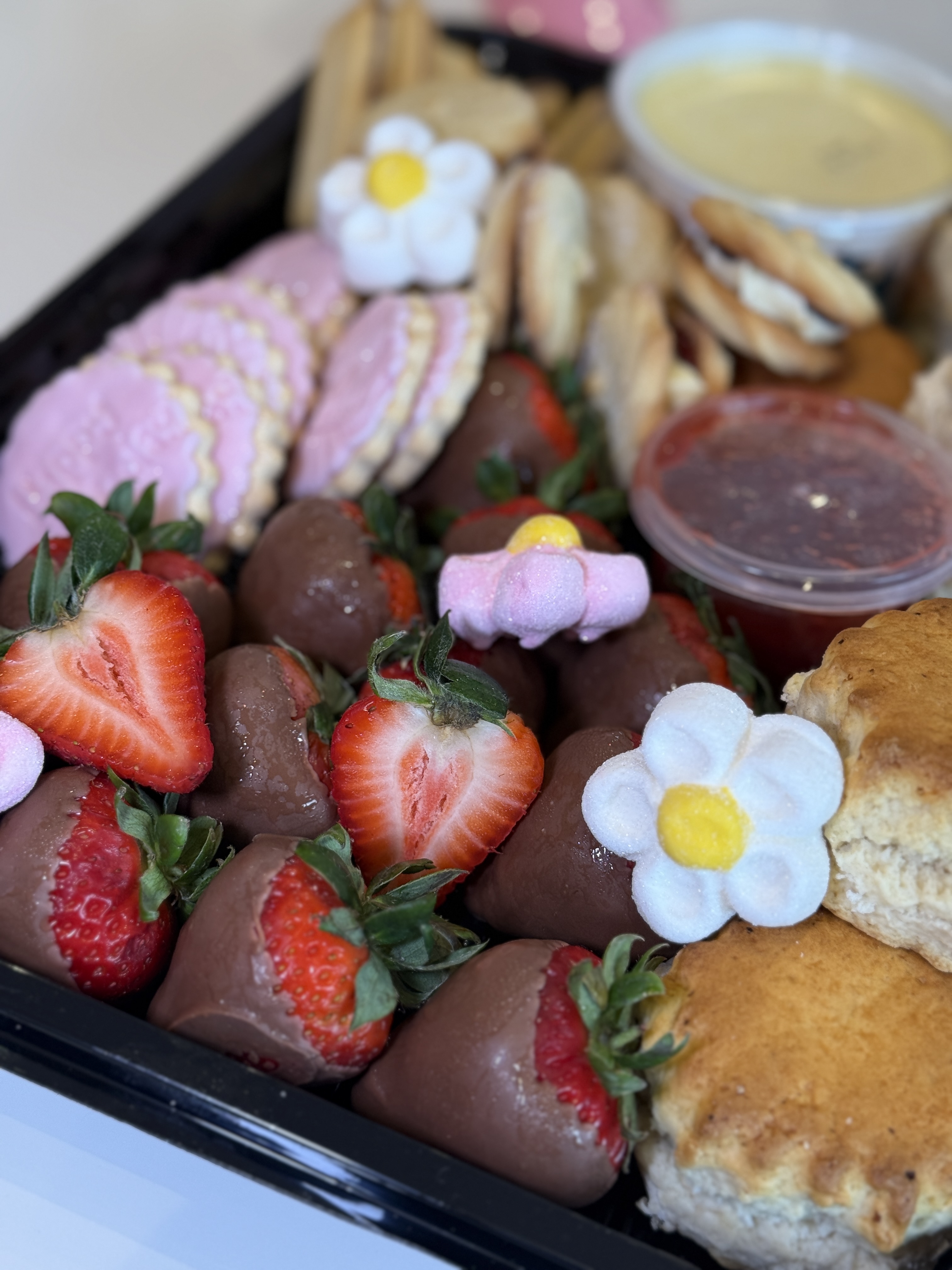 Fresh chocolate-dipped strawberries, scones, clotted cream & iced party biscuits