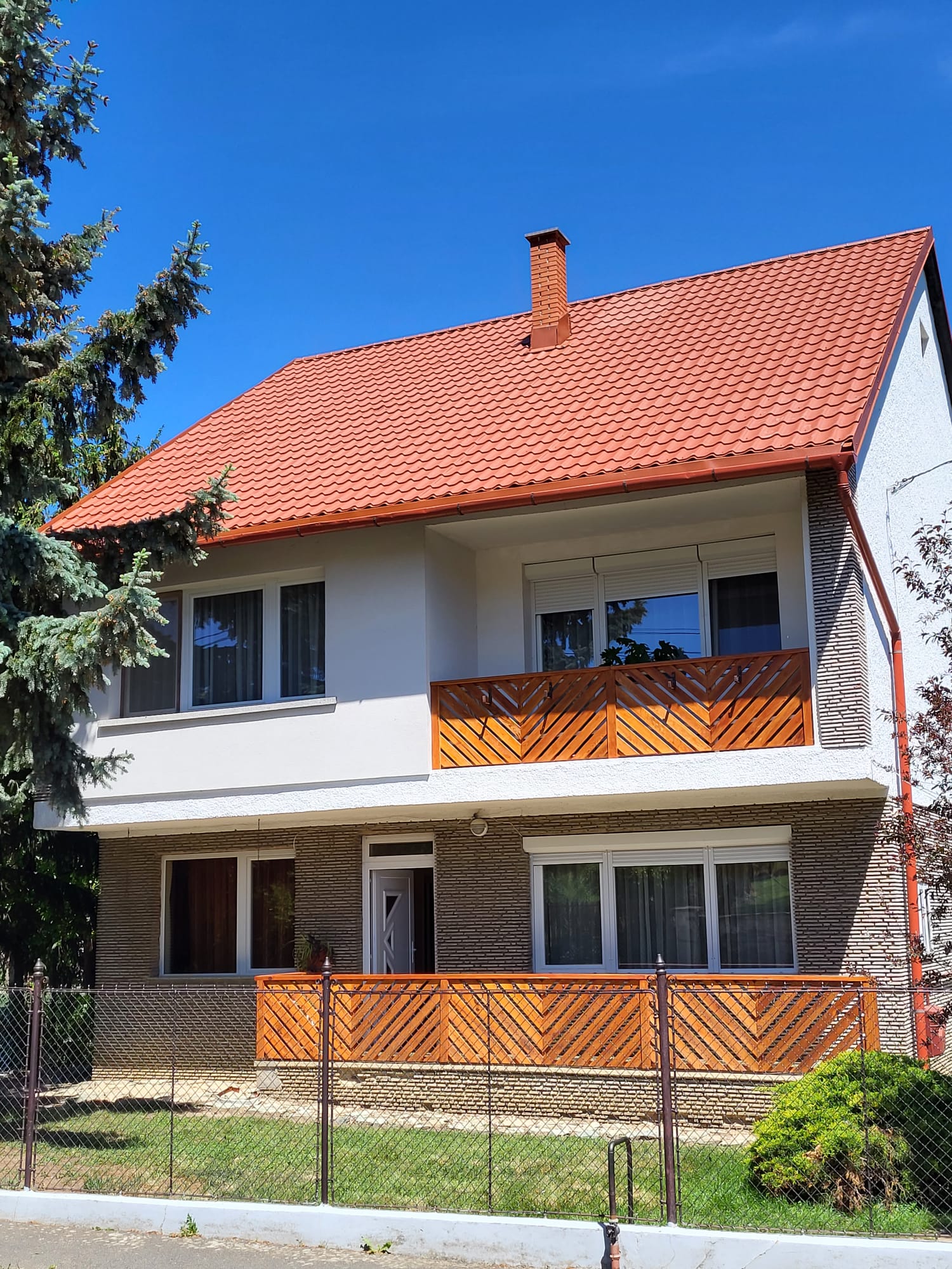 Téglavörös cserepeslemez emeletes családi házon