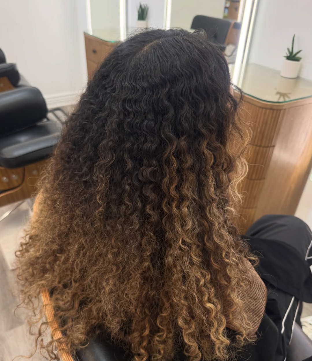 Long defined curls cut and styled in salon chair at Hideaway Salon