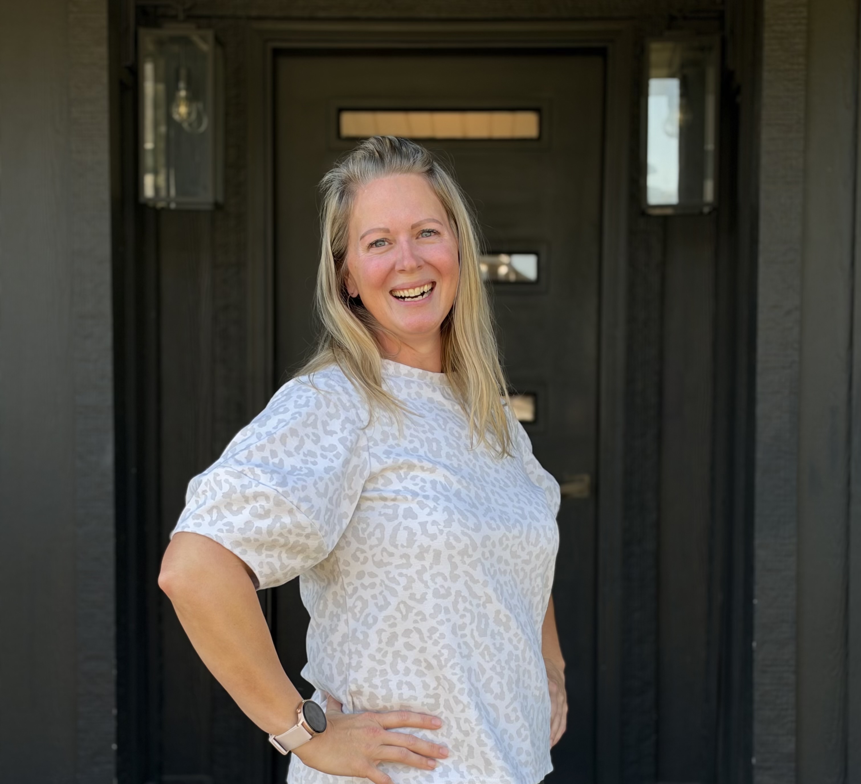 Carrie smiling in front of doorway