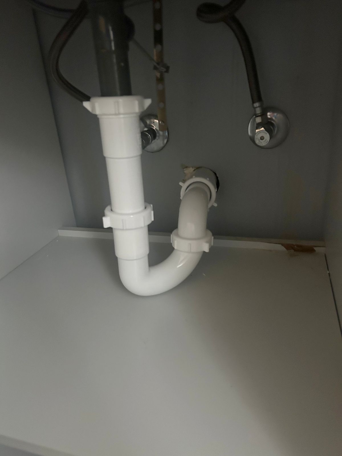 New white PVC P-trap under a bathroom sink