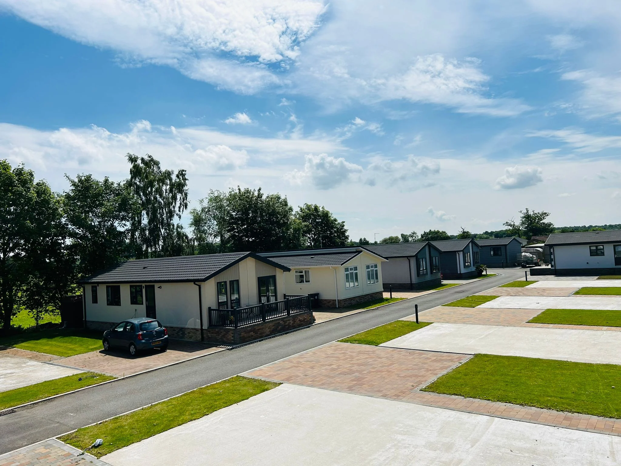 Elvington Residential Park homes along a quiet tree-lined lane with open skies