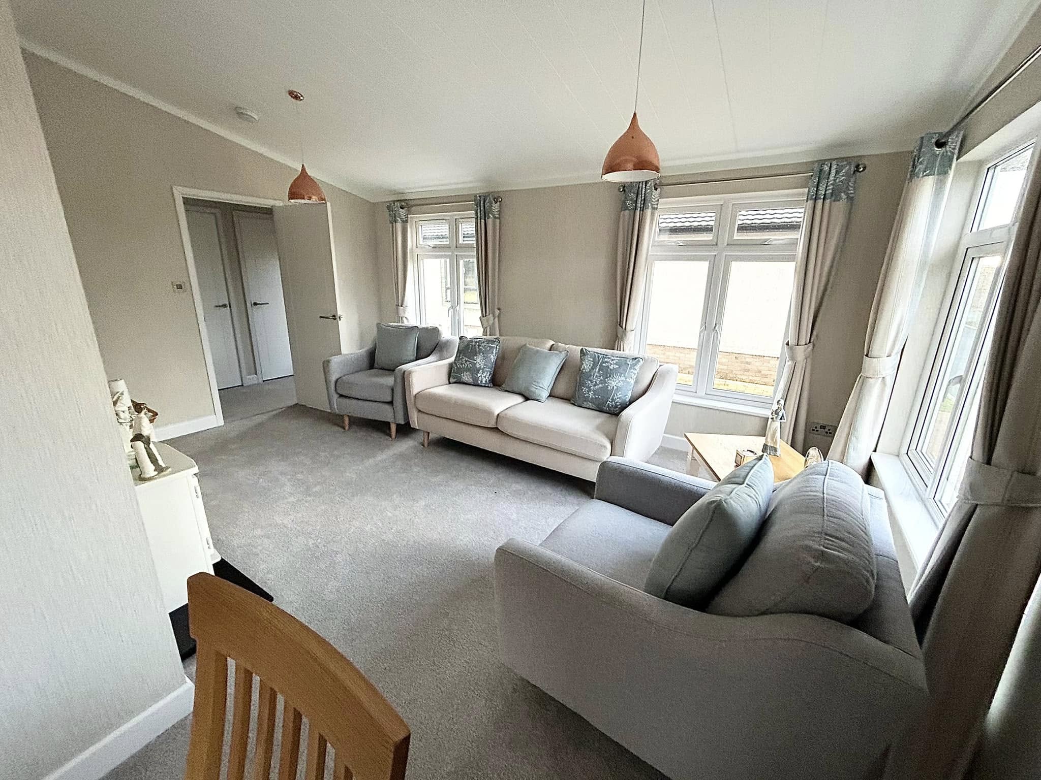 Spacious, bright park home living room with comfortable sofas and vaulted ceiling