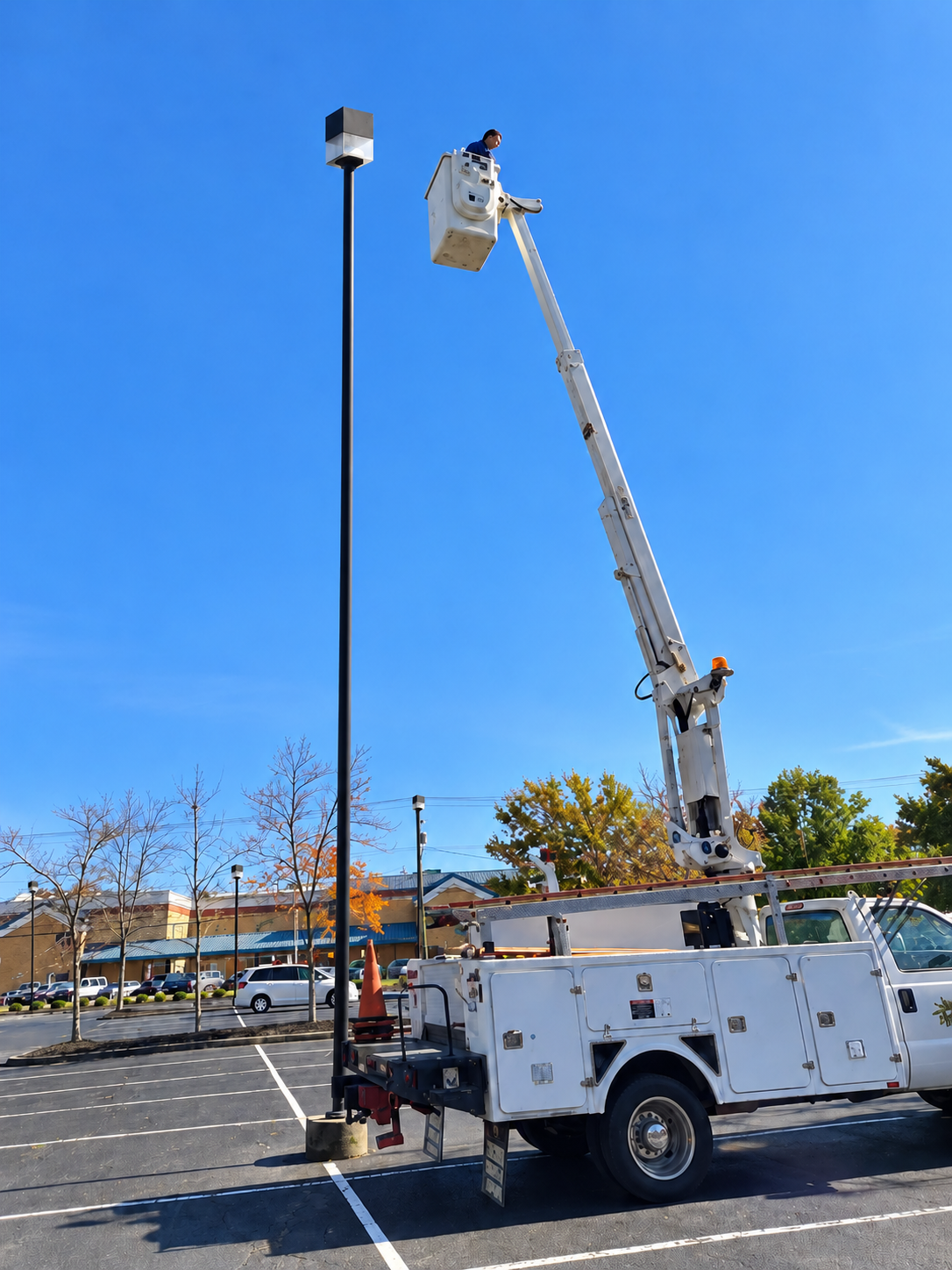 Nor'Easter bucket truck servicing a commercial parking lot light fixture