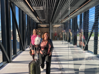 Pilgrims walking with carry-on luggage through the airport heading on journey