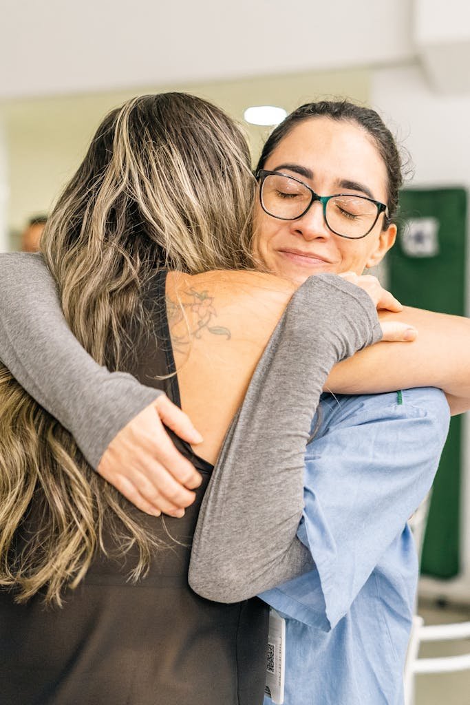 Two individuals embracing warmly, communicating compassion, dignity, and encouragement
