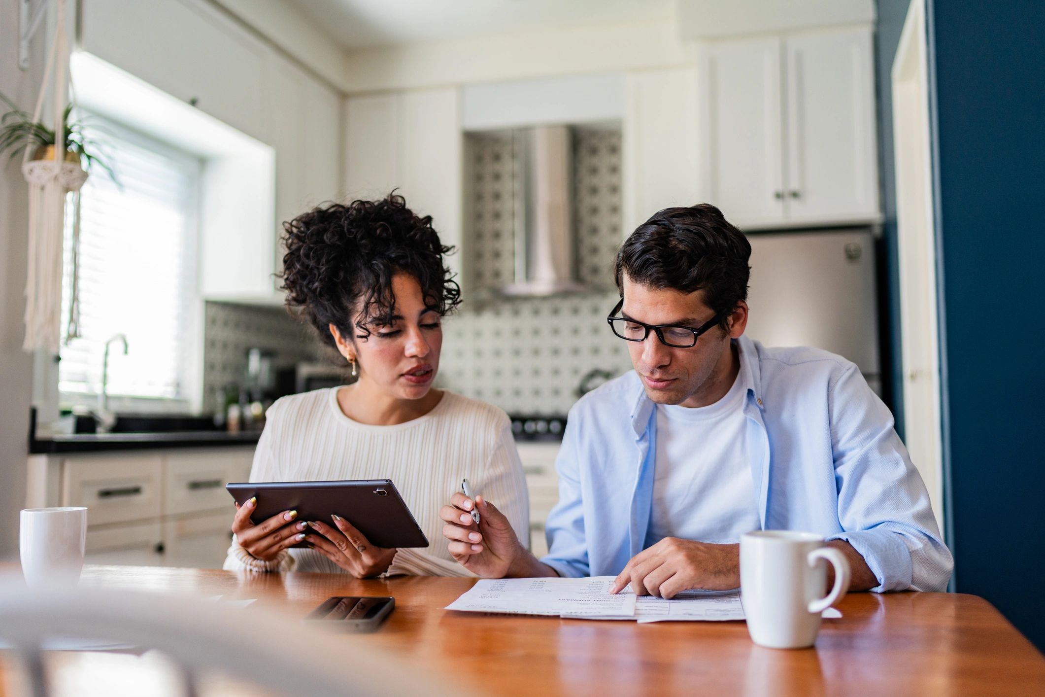 A couple reviewing household paperwork together at home